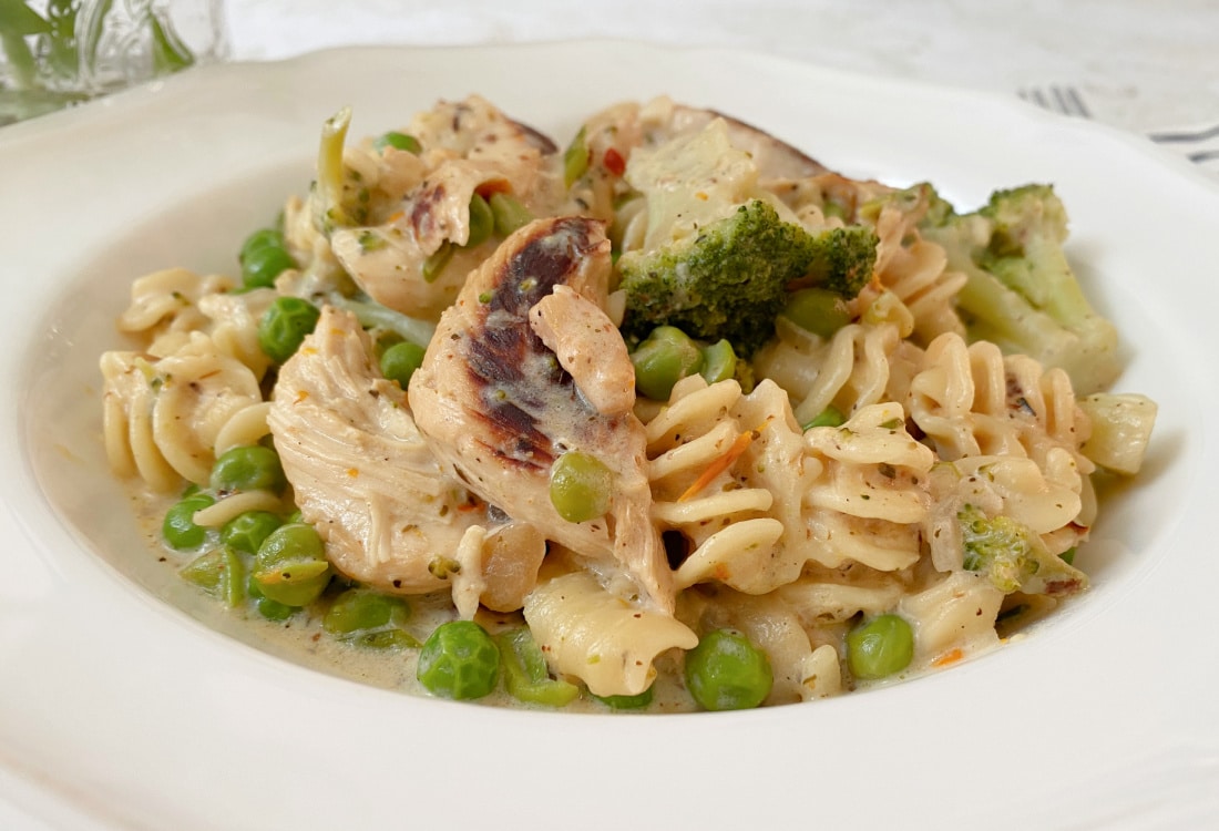 easy weeknight cajun chicken pasta with veggies served in a white bowl - Life Full and Frugal - Easy Cajun Chicken Pasta
