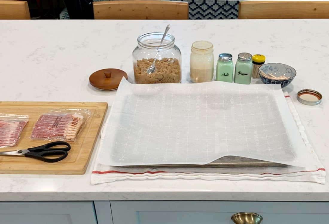 ingredients for bacon wrapped green bean bundles - bacon, brown sugar, garlic powder, salt, pepper, toothpicks and a cookie sheet covered in parchment paper - Life Full and Frugal