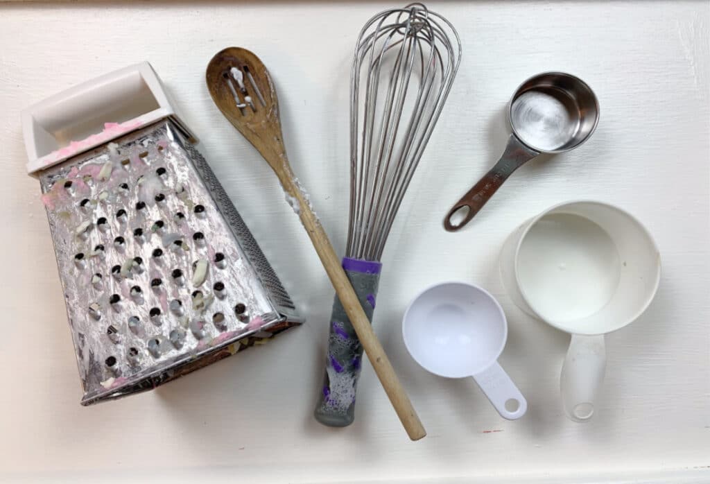 a box grater wooden spoon whisk and measuring cups