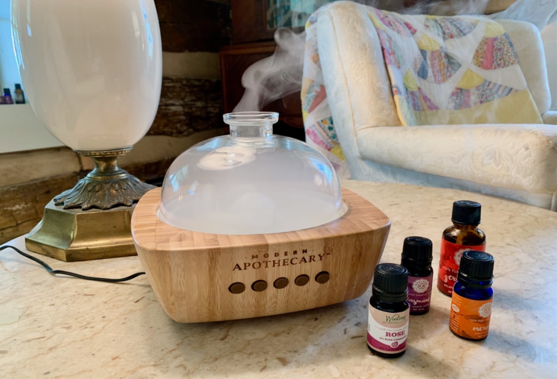 an essential oil diffuser and essential oils on a marble table hygge home