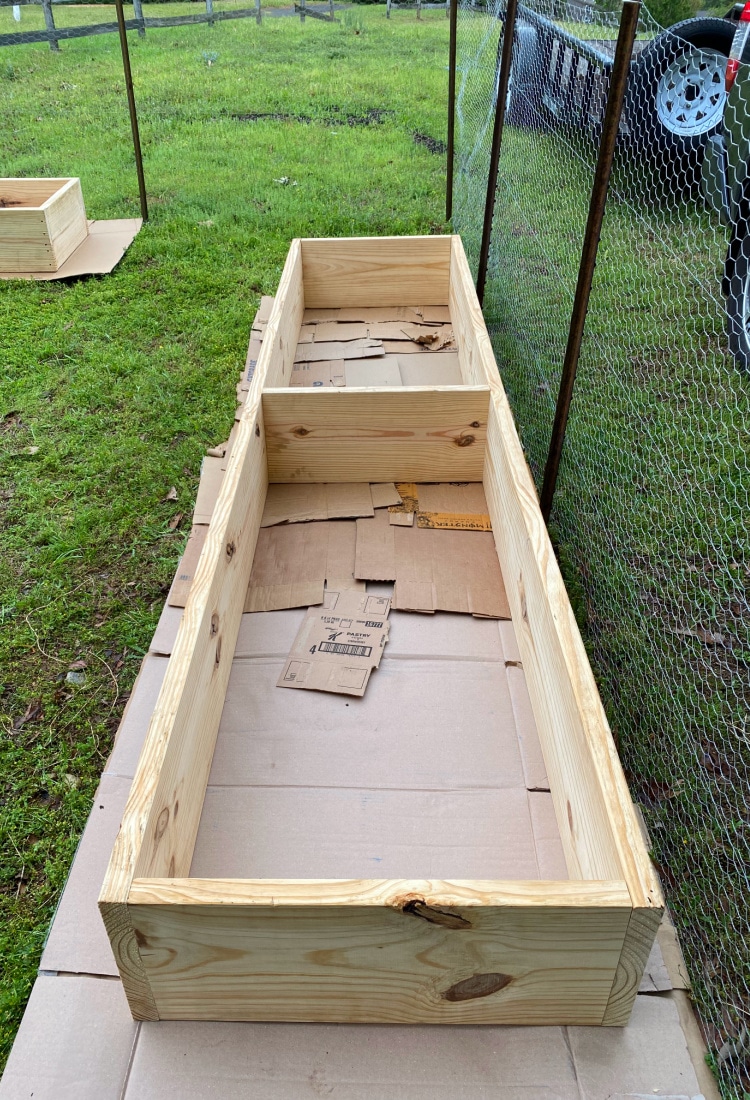 recycled boxes placed under garden box to prevent weeds from growing - DIY Raised Bed Garden Boxes - Life Full and Frugal