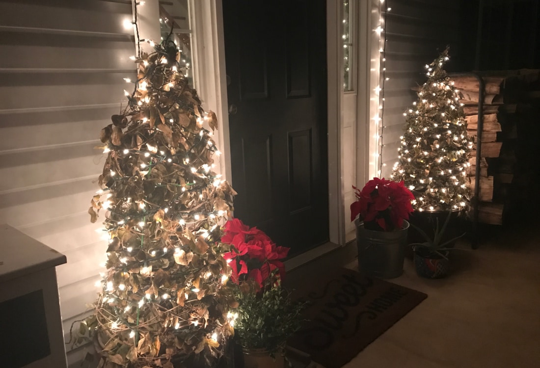 front porch decorated for Christmas with tomato cage Christmas trees, soft light, and red poinsettias - Tomato Cage Christmas Trees - Life Full and Frugal
