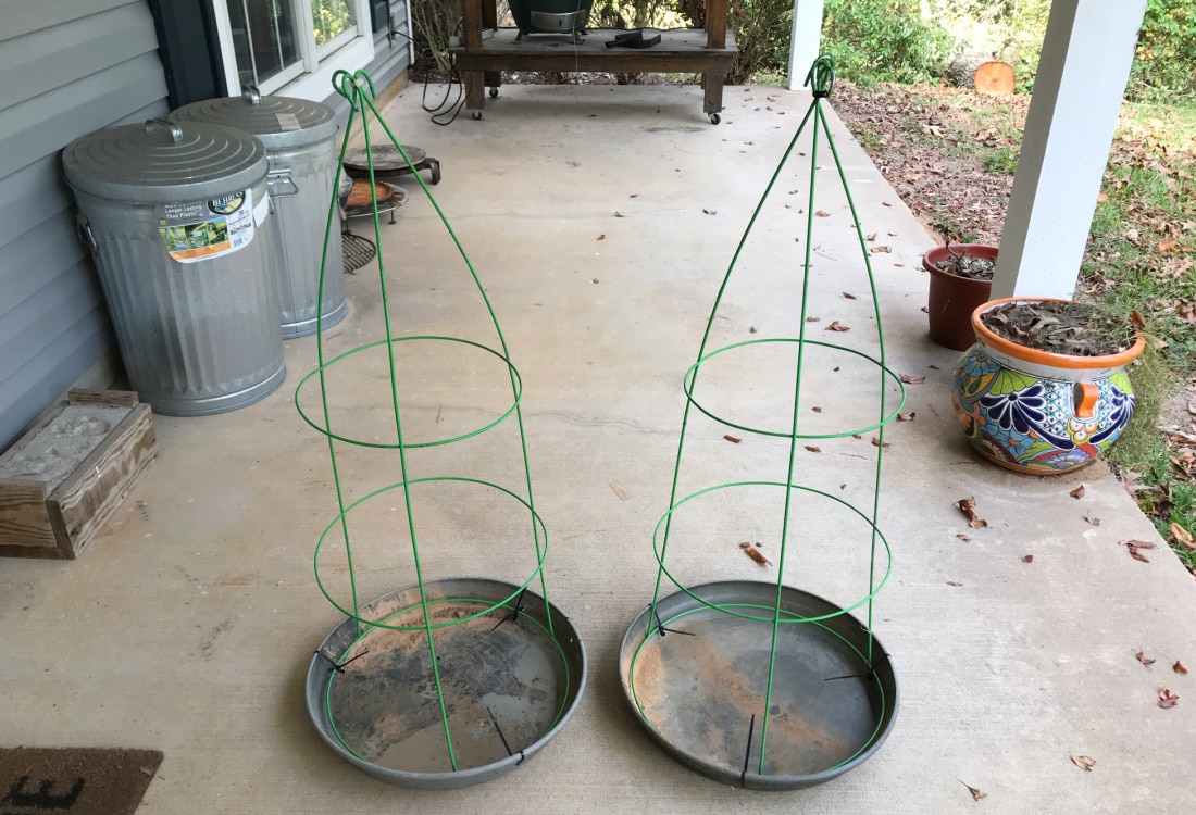 two tomato cages turned upside down and attached at the legs to form Christmas trees, attached to plant saucers for a base - Tomato Cage Christmas Trees - Life Full and Frugal