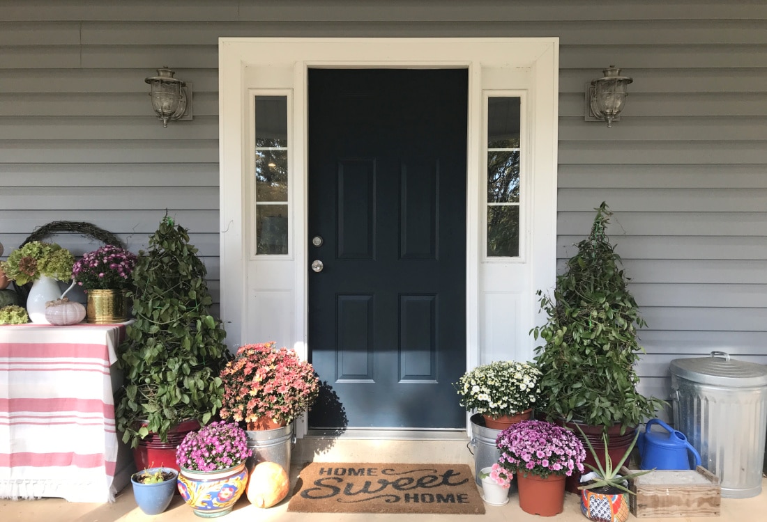front porch all decorated for fall with tomato cage Christmas trees, pumpkins, mums and a home sweet home welcome mat - Easy DIY Christmas Trees Using Tomato Cages - Life Full and Frugal