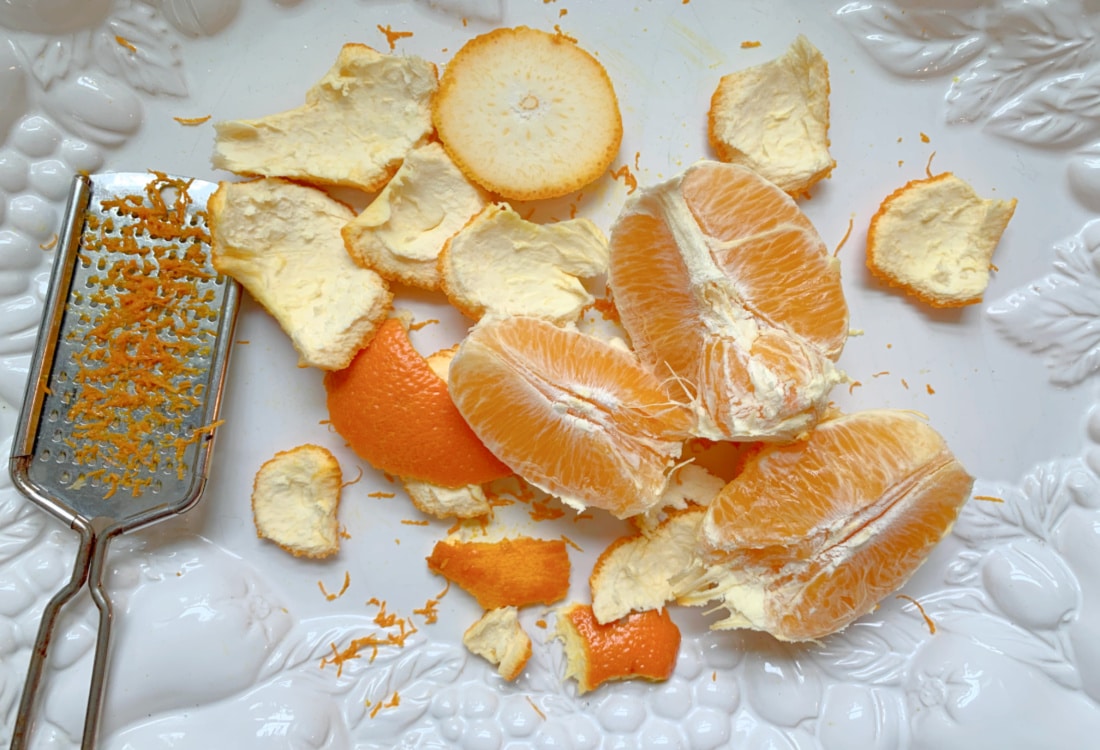 orange peels, orange wedges and zester on a white platter - Probiotic Yogurt Dreamsicles - Life Full and Frugal